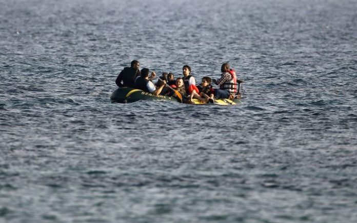 Migrants approach a beach after crossing from Turkey to Greece on the island of Kos